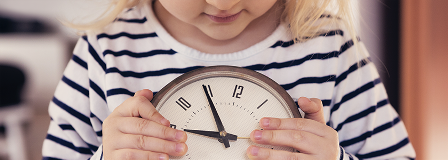 Little girl holding a clock