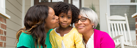 Mom and grandmom sit on either side of child