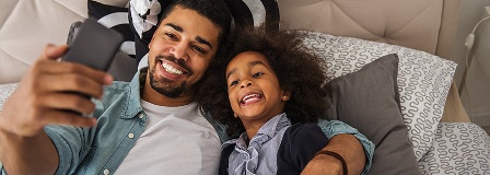 Father and daughter smile for a selfie