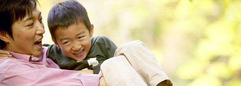 Father laughing while holding son