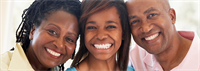 Mother, teenaged daughter, and father smile broadly  at the camera