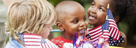 Smiling children celebrating with American flags