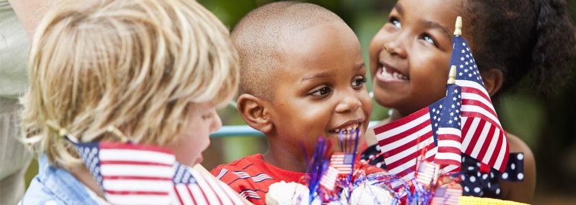Smiling children celebrating with American flags