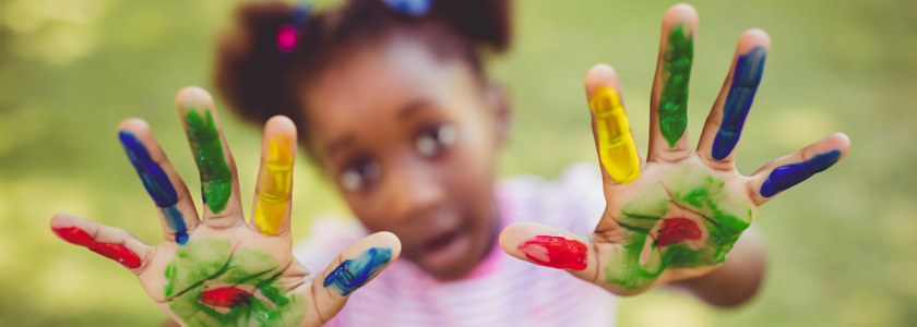 Little girl holding up her ten painted fingers