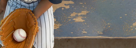Boy on bench with glove with baseball
