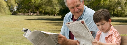 Grandfather and grandson reading a newspaper together