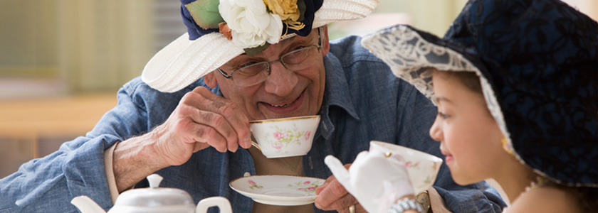 Grandfather and granddaughter having a tea party