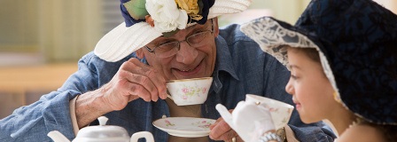 Grandfather and granddaughter having a tea party