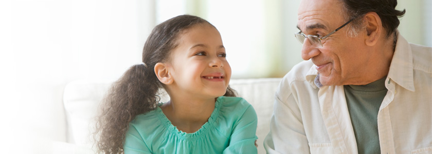 Granddaughter and grandfather smiling at each other