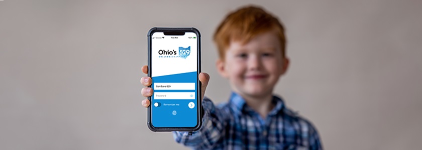Little boy holding a cell phone with the Ohio READYSAVE 529 app on screen