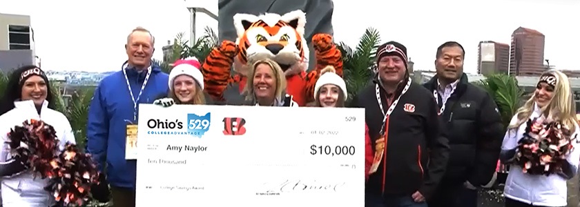 GENERAL_243 Cincinnati Bengals Kickoff College Savings grand-prize winner Amy Naylor accepts her $10,000 college savings award from Ohio's 529 Plan Executive Director Tim Gorrell.