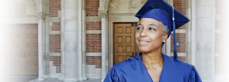 An older woman standing proudly in her mortar board and gown