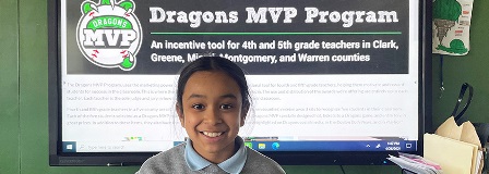 Smiling girl standing in front of the Dayton Dragons MVP Program computer screen