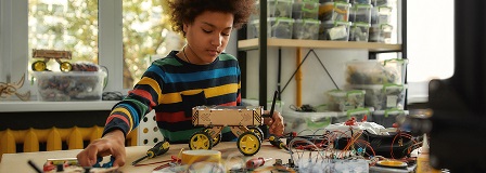 Young teen creating a moving piece of machinery