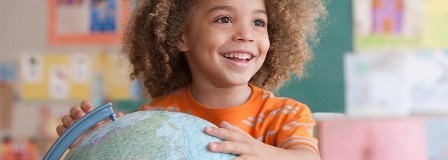 Smiling child holding a globe