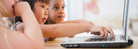 Three small children working on laptop