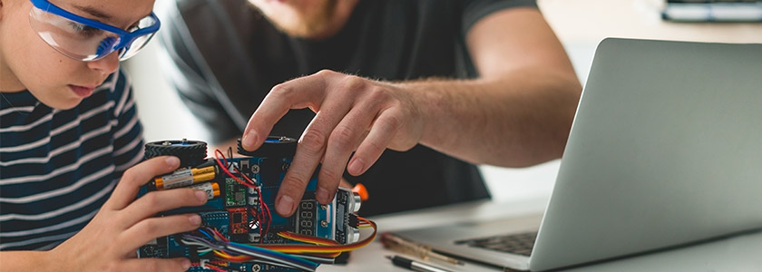 Child and father testing and building a robot