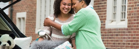 Mother hugging her college-aged daughter on campus