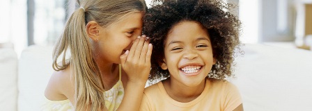 Girl whispers in her friend's ear
