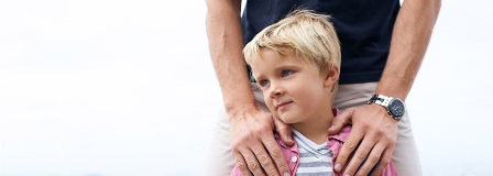 Father reassuringly places his hands on his son's shoulders