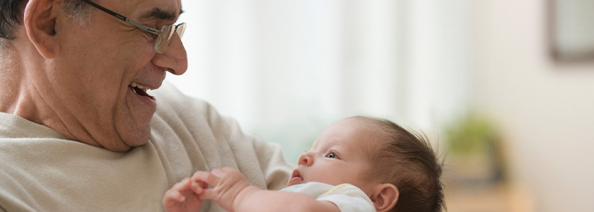 Grandfather smiling at newborn grandson