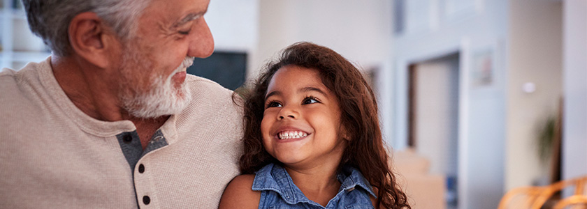 Granddaughter smiles up at her grandfather