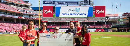 2023 Cincinnati Reds College Savings Grand Slam winner Claire Wright and her family accept her check from Ohio's 529 plan Executive Director Trisha Good.