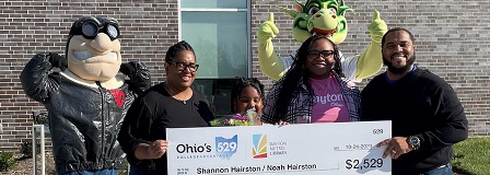 Dayton Metro Library Summer Challenge winner Noah Hairston and her family celebrates with Rudy and Heater at check presentation.