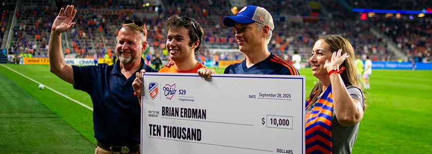 Family holds oversized check from Ohio 529 and FC Cincinnati on field at TQL Stadium