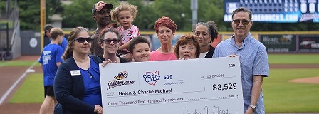 2026 RubberDucks Most Improved Student winner stands with his family, holding an oversized check