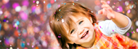 Little girl smiles at the camera as confetti falls around her