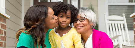 Mother and grandmother hug the little girl between them
