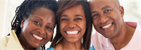 Parents smile proudly at camera with daughter in between