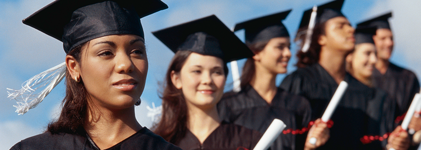 A line of recent graduated hold their diplomas
