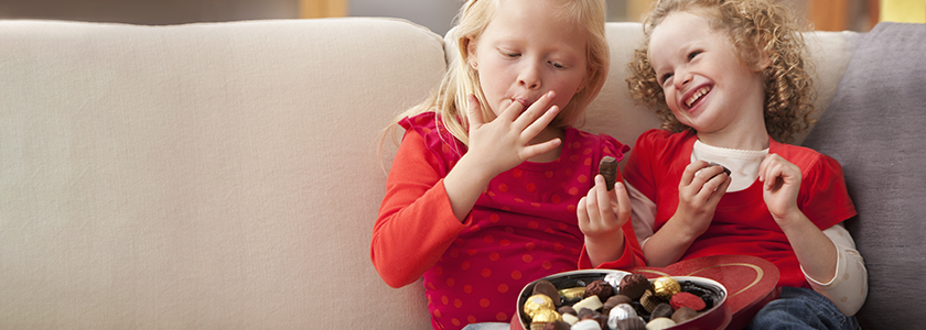 Fall In Love With Ohio's 529 Plan Two sisters eating chocolates from a heart-shaped box