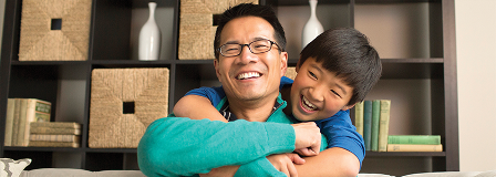 Smiling dad and son hugging each other