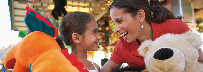 Daughter and Mom laughing after winning prizes at a carnival game