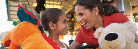 Daughter and Mom laughing after winning prizes at a carnival game