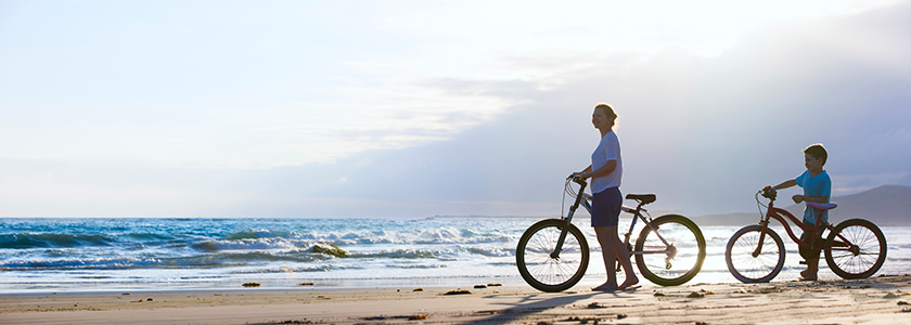 Mom and son with bikes at the beach