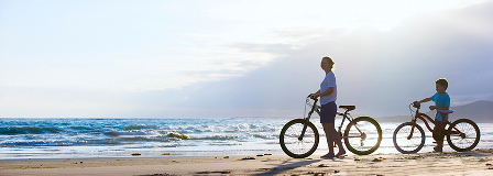 Mom and son with bikes at the beach